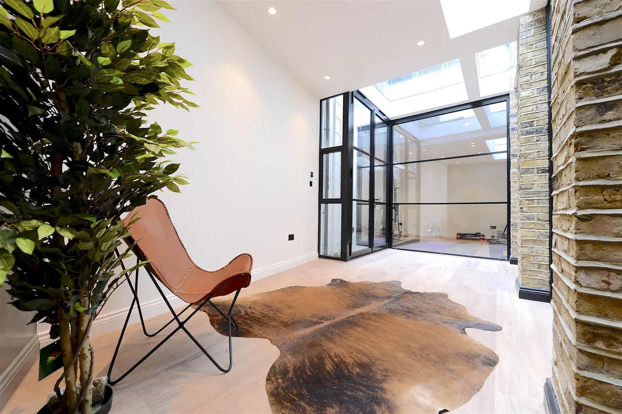 Glazed screen dividing the living space, with polished plaster beyond